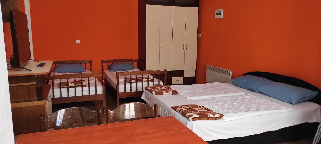 a room with three beds in a room with orange walls at Apartment Sekulovski in Ohrid