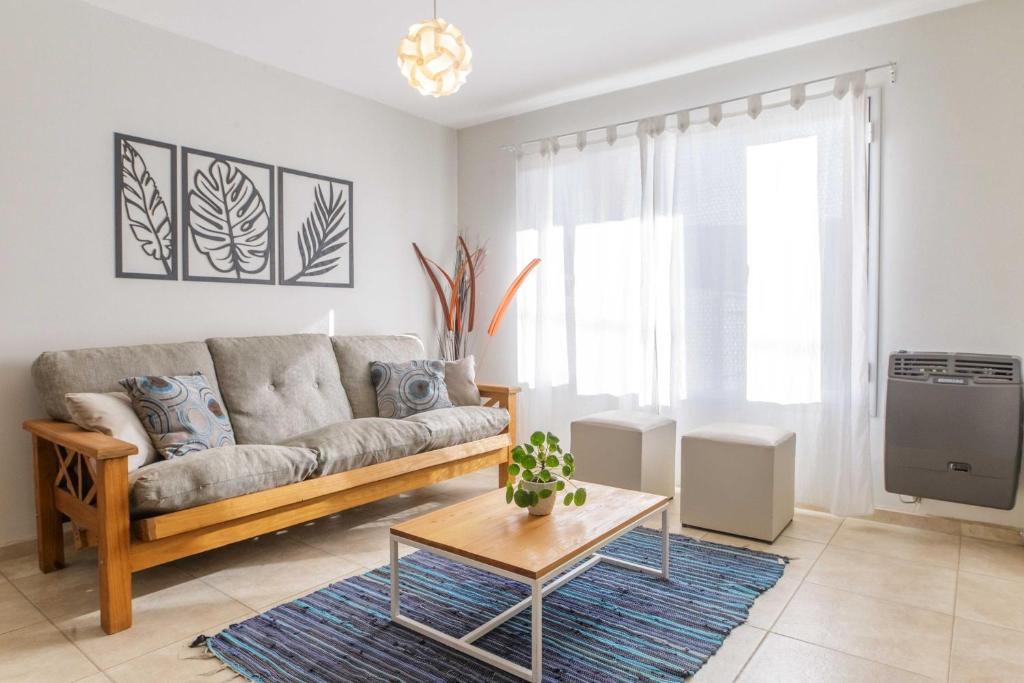 uma sala de estar com um sofá e uma mesa em Alojamiento Amor Amarillo em El Bolsón