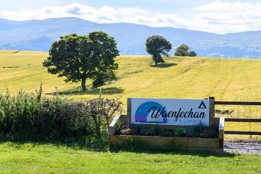 a sign in a field next to a fence at Waenfechan Glamping in Colwyn Bay