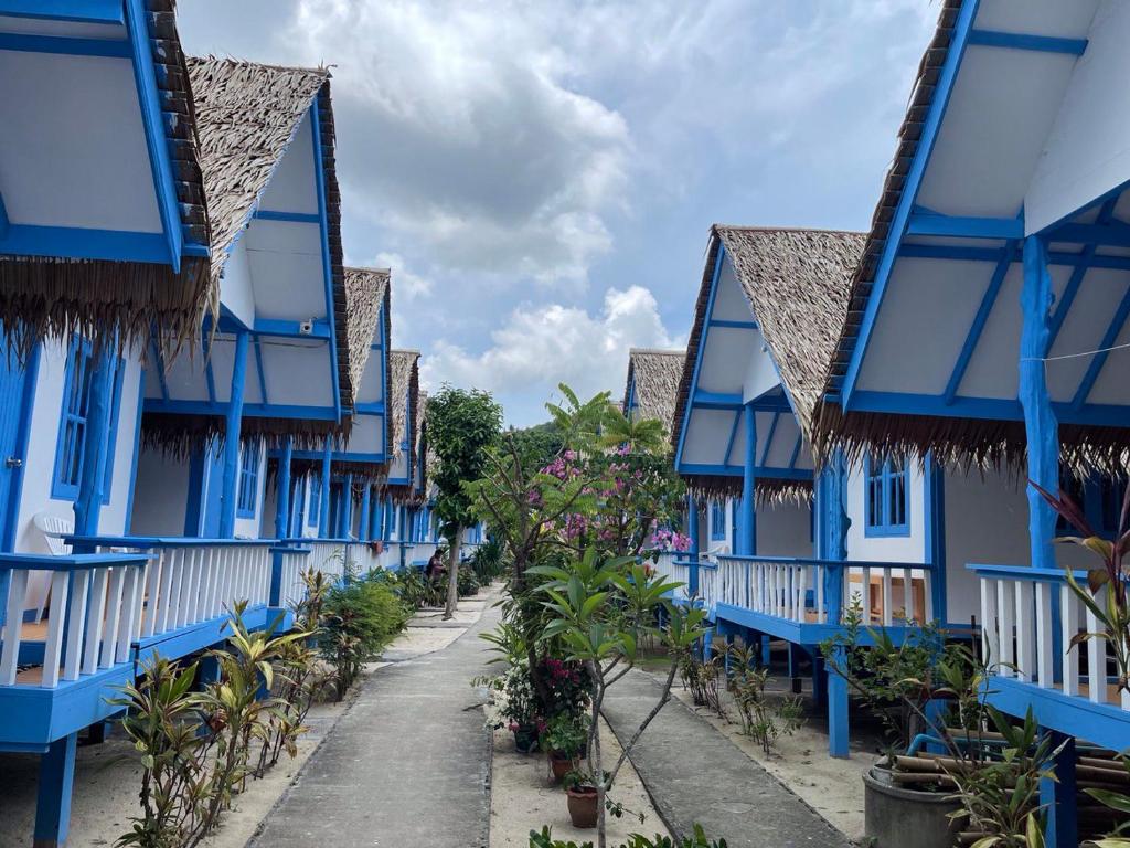 Ko Phangan Beach Cottages في بان تاي: صف من البيوت الزرقاء على شارع