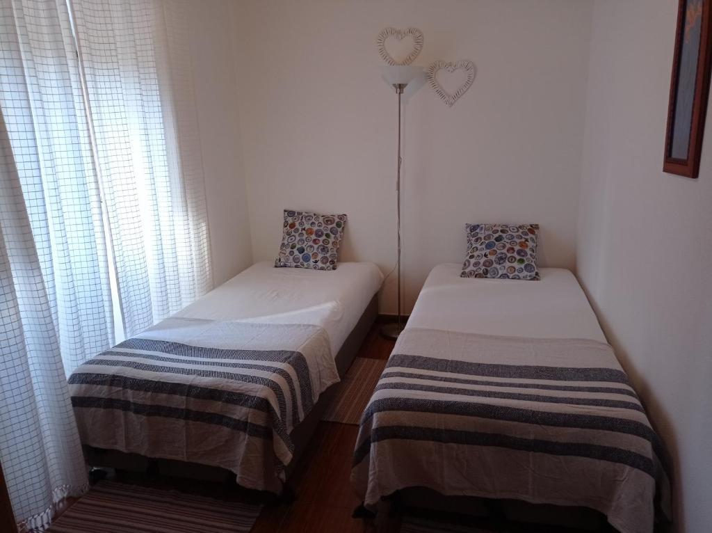 twee bedden in een kleine kamer met een raam bij Apartamento 1 - Fundação de Veiros in Veiros
