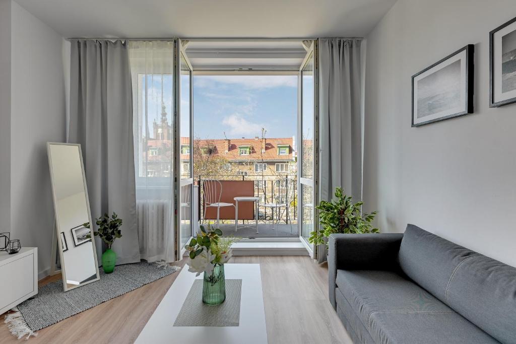 a living room with a couch and a large window at Downtown Apartments Old Town Stolarska in Gdańsk