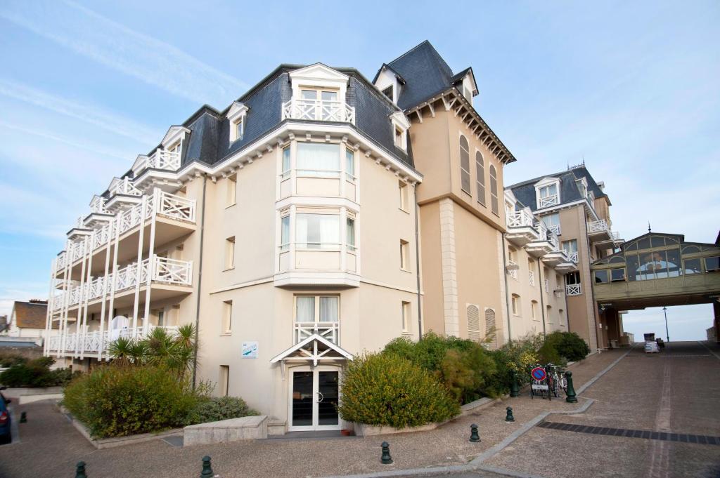 a large white building with a black roof at Résidence Neptunia in Saint Malo