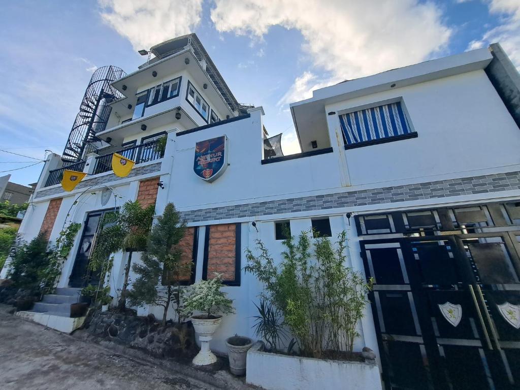 a white building with a sign on it at Arthur Private Resort in Legazpi