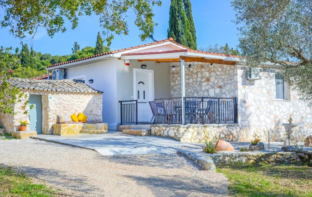 a stone house with a gate and a driveway at Green Oak Villa in Orthoniaí