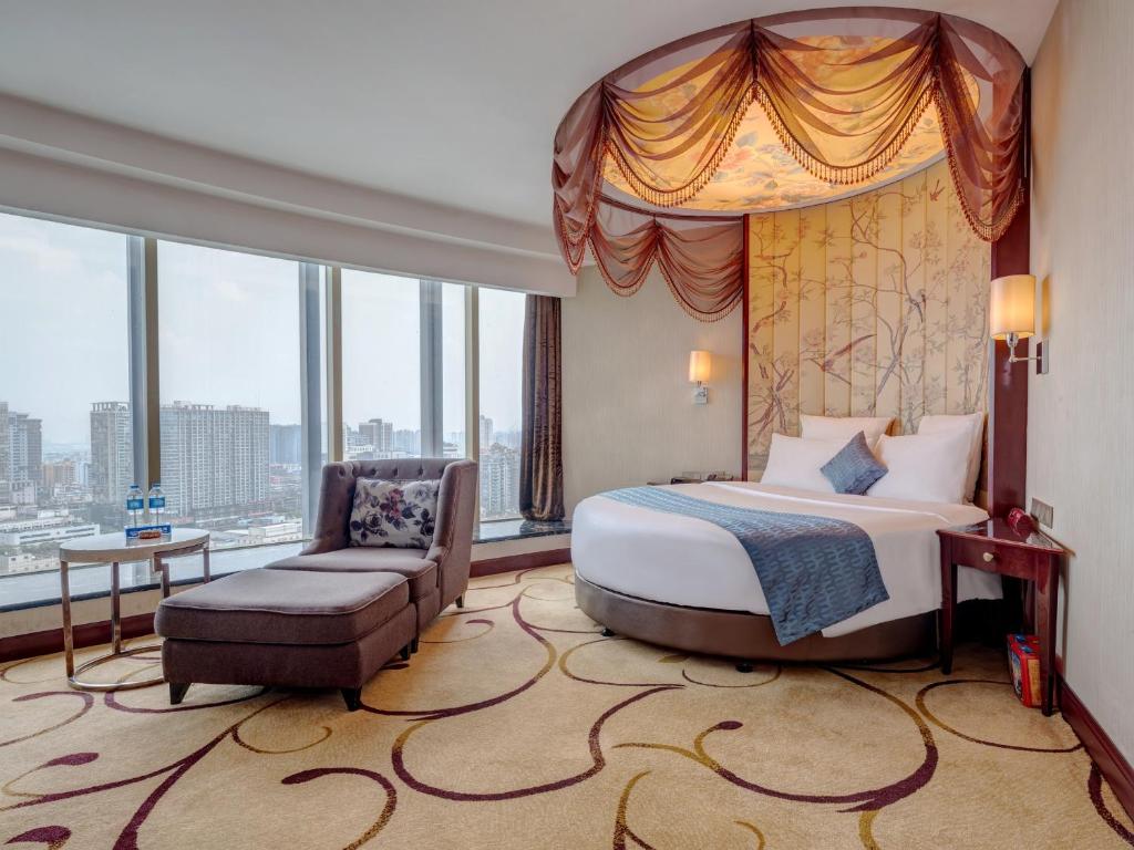 a bedroom with a king sized bed and a chair at Days Hotel & Suites China Town - Metro Line 2 - Nearby Wuyi Square ,Orange Island,Hunan Museum in Changsha