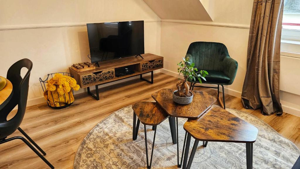 sala de estar con TV, silla y mesa en Logements neufs à Bannalec Centre, en Bannalec