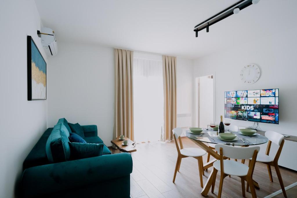 uma sala de estar com uma mesa e um sofá azul em Terra Apartments em Vrnjačka Banja