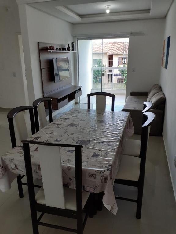 mesa de comedor con sillas, mesa y sofá en Belo e Amplo Apartamento, Área Central da Praia dos Ingleses, en Florianópolis