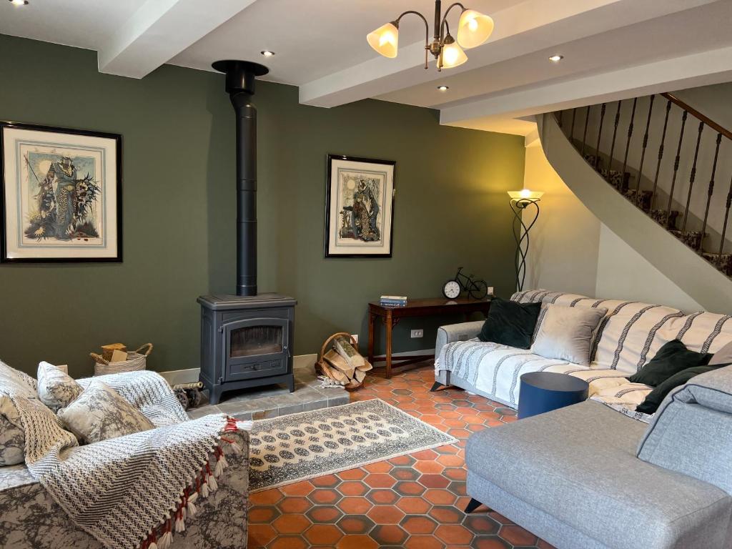 uma sala de estar com um sofá e um fogão a lenha em Maison de riviere em Limoux