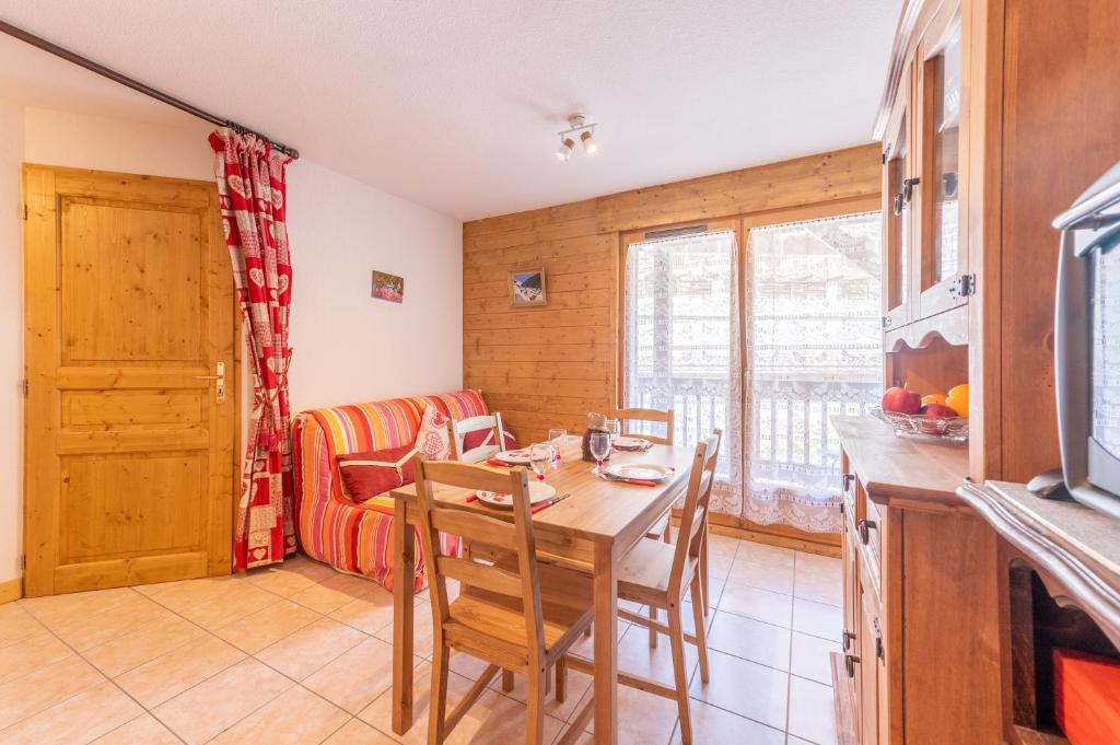 a kitchen and dining room with a table and chairs at La Ferme des Alpages - Proche pistes de ski in La Giettaz