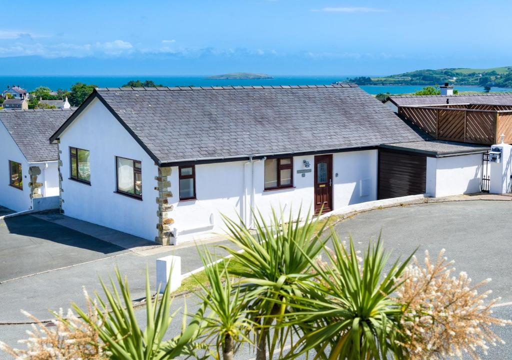 a white house with the ocean in the background at Kookaburra in Abersoch