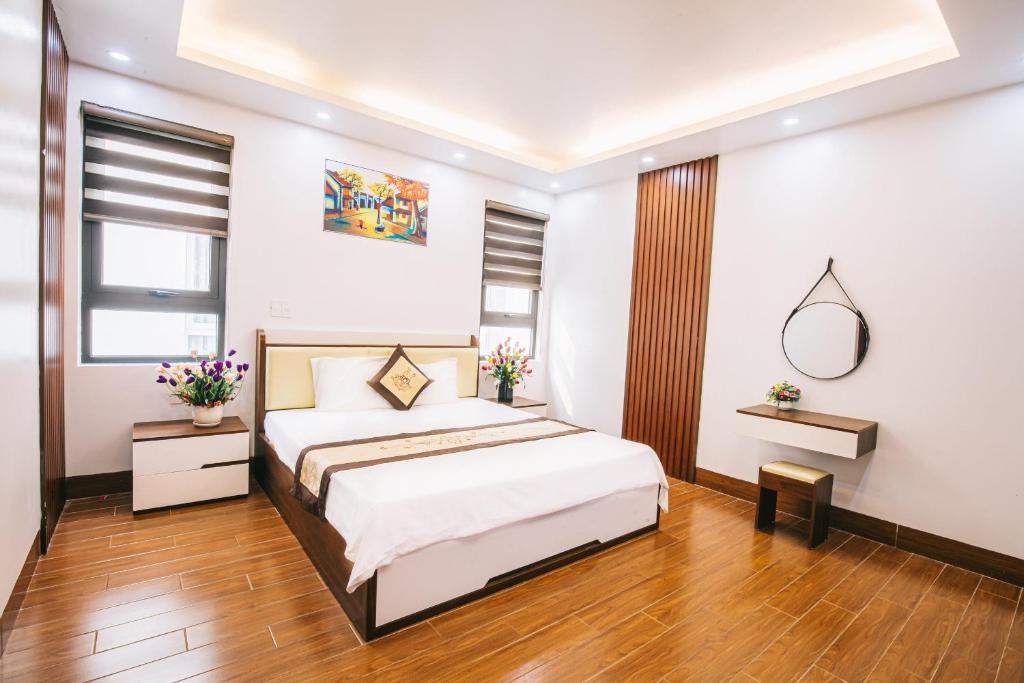 a bedroom with a large bed and wooden floors at Villa FLC Sầm Sơn in Sầm Sơn