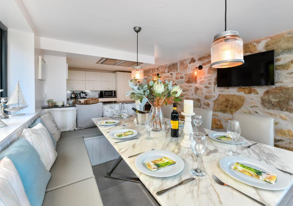 a kitchen and living room with a dining table and chairs at 1 Fron Dirion in Llanbedrog
