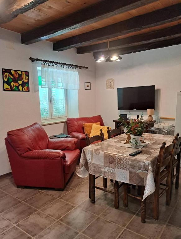 a living room with a table and a red couch at Villa Malini in Grožnjan