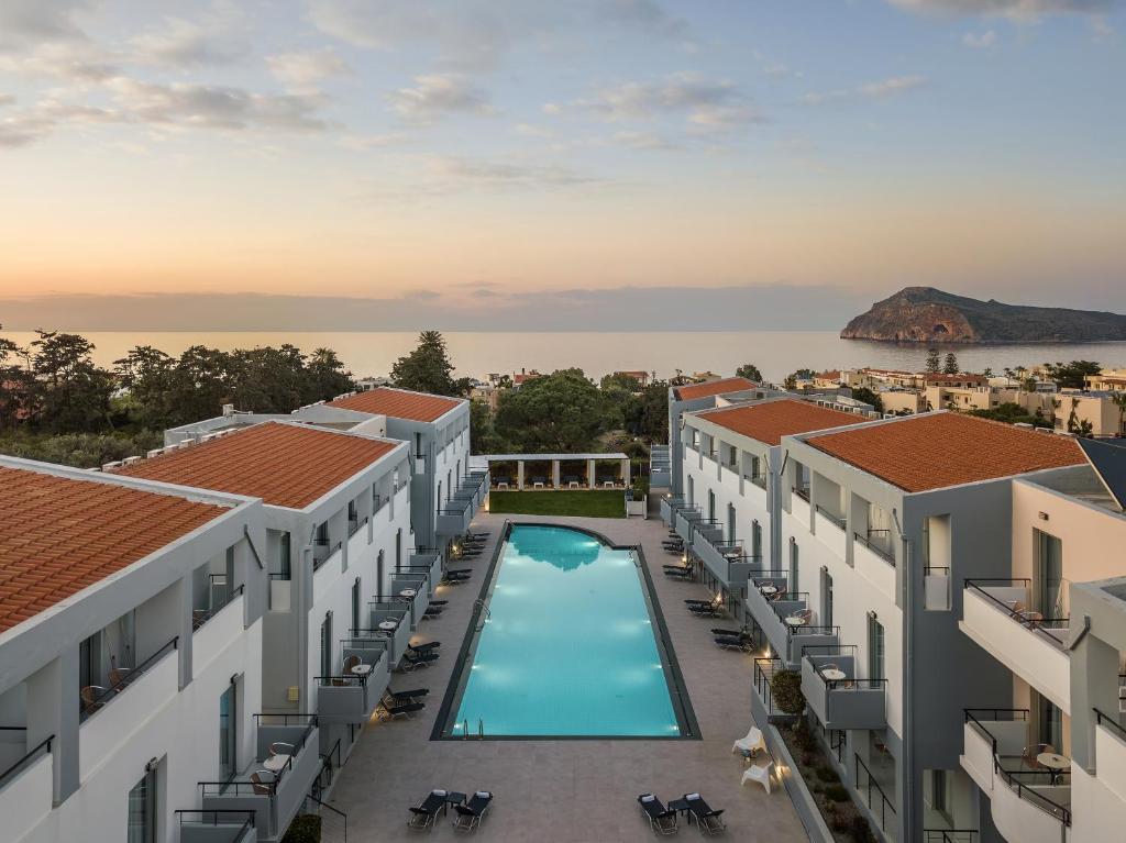 eine Luftansicht auf den Innenhof eines Gebäudes mit Pool in der Unterkunft Sunrise Village Hotel - All Inclusive in Platanias