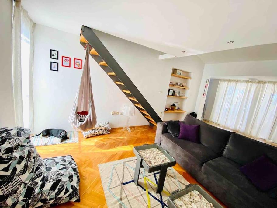 Pet-friendly two-room family apartment in magical Bale في بال: غرفة معيشة مع أريكة سوداء وأرجوحة