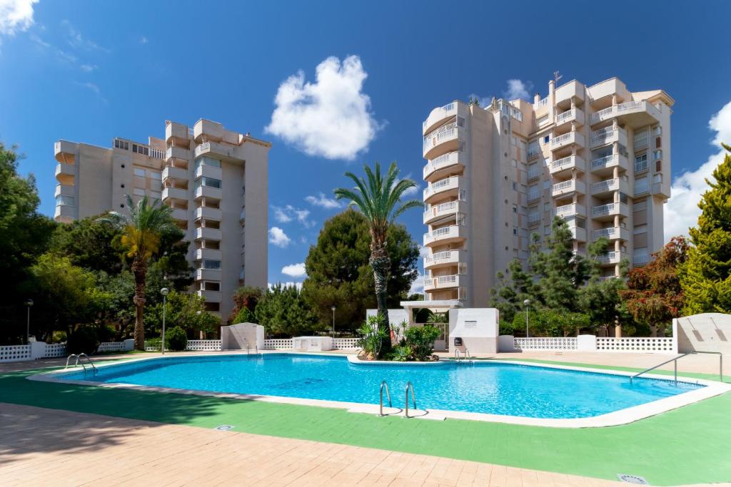 een zwembad voor twee appartementsgebouwen bij Espanatour CAMPOAMOR in Orihuela