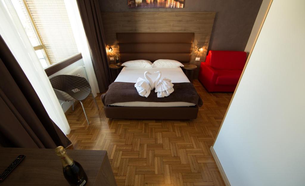um quarto com uma cama e uma cadeira vermelha em Love of Rome em Roma