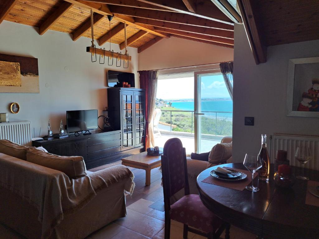 Sala de estar con mesa y vistas al océano en Attic, en Nea Moudania