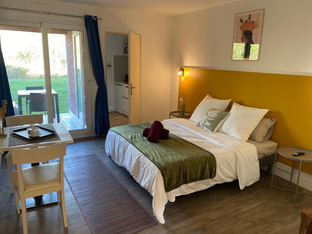 1 dormitorio con cama, mesa y escritorio en Joli Appartement 27m2 Oasis Provençale en village vacances en Camargue, en Arles