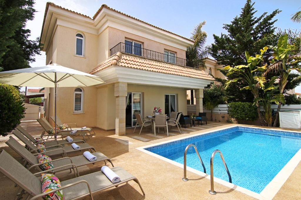 a villa with a swimming pool and a house at Villa Alyson in Paralimni
