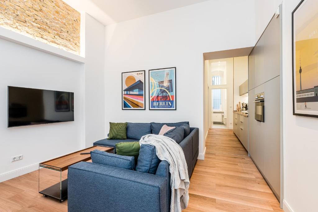 a living room with a blue couch and a tv at Neues Design-Apartment in Friedrichshain in Berlin