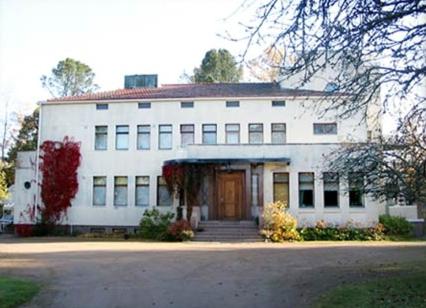 un gran edificio blanco con puerta delantera en Villa Helleranta, en Ulvila