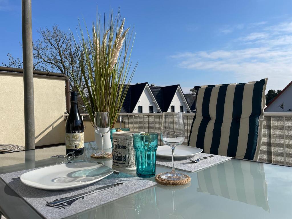 a table with a bottle of wine and glasses on a balcony at Sonnendeck 3 in Zingst