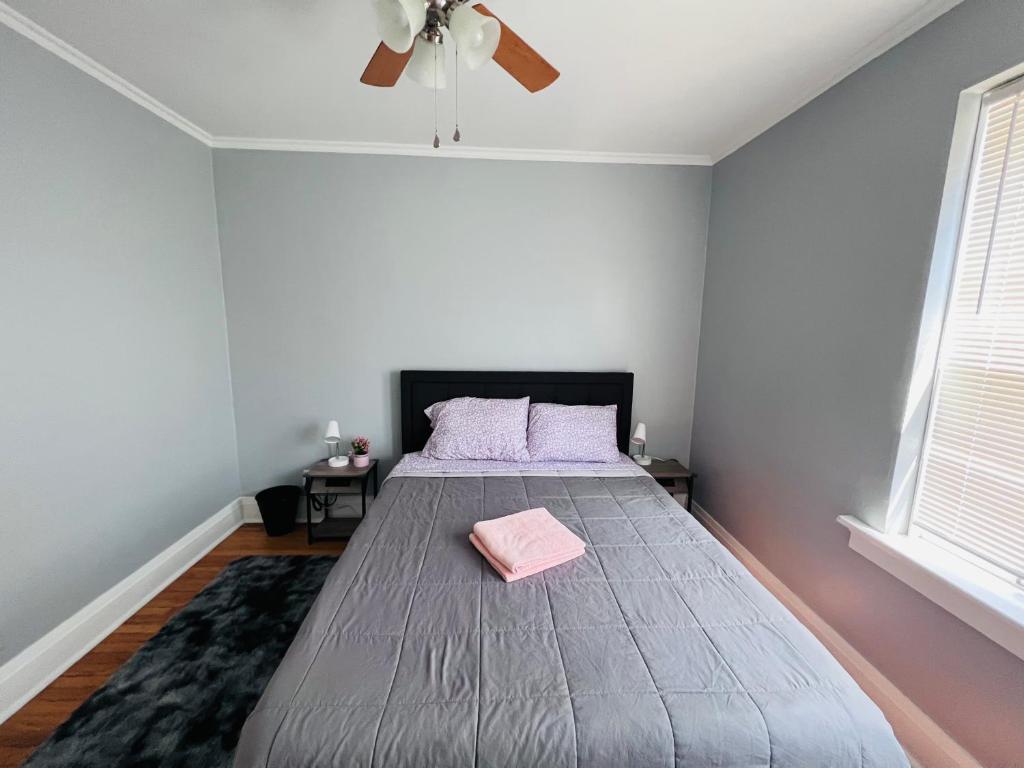 a bedroom with a large bed with a ceiling fan at Dale first floor in Richmond Heights