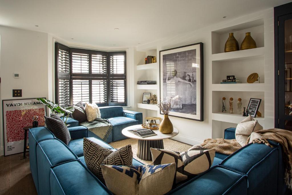 ロンドンにあるThe Luxury Fulham Townhouseのリビングルーム(青いソファ、テーブル付)