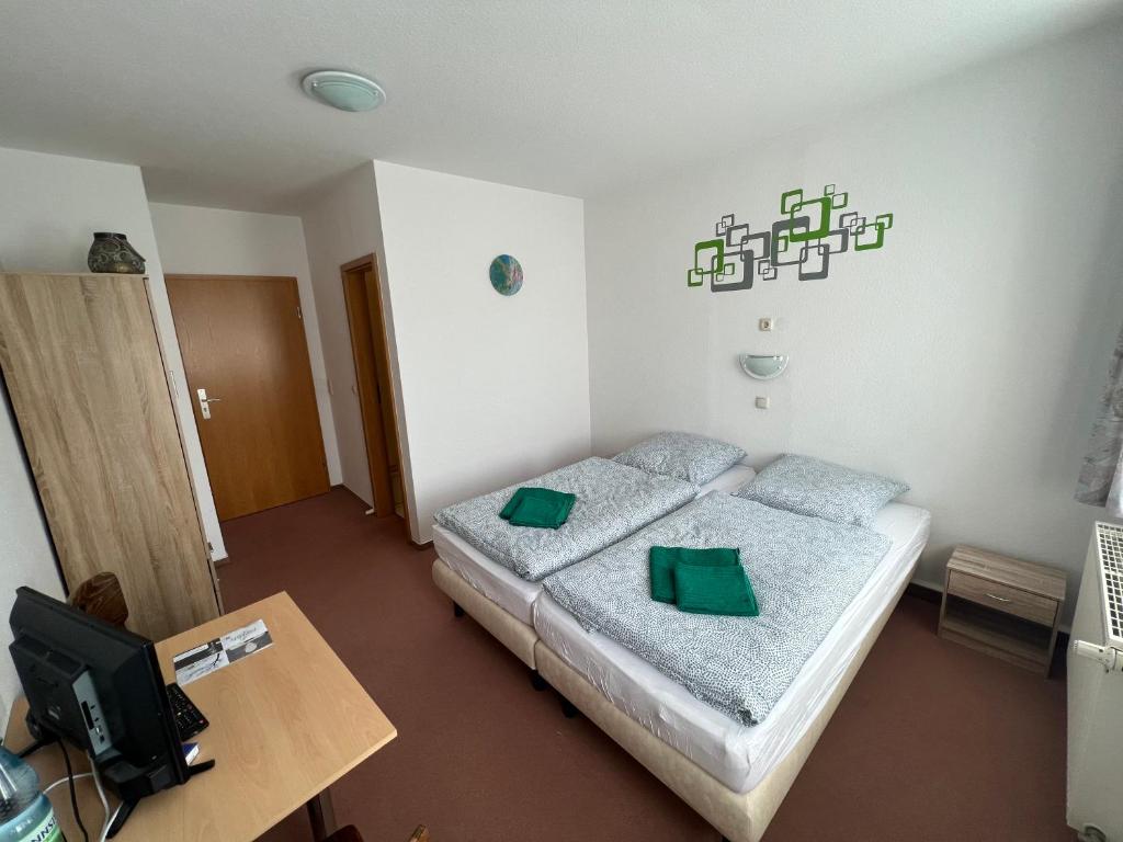 a bedroom with a bed with green pillows on it at Pension zur Bergbahn in Lichtenhain