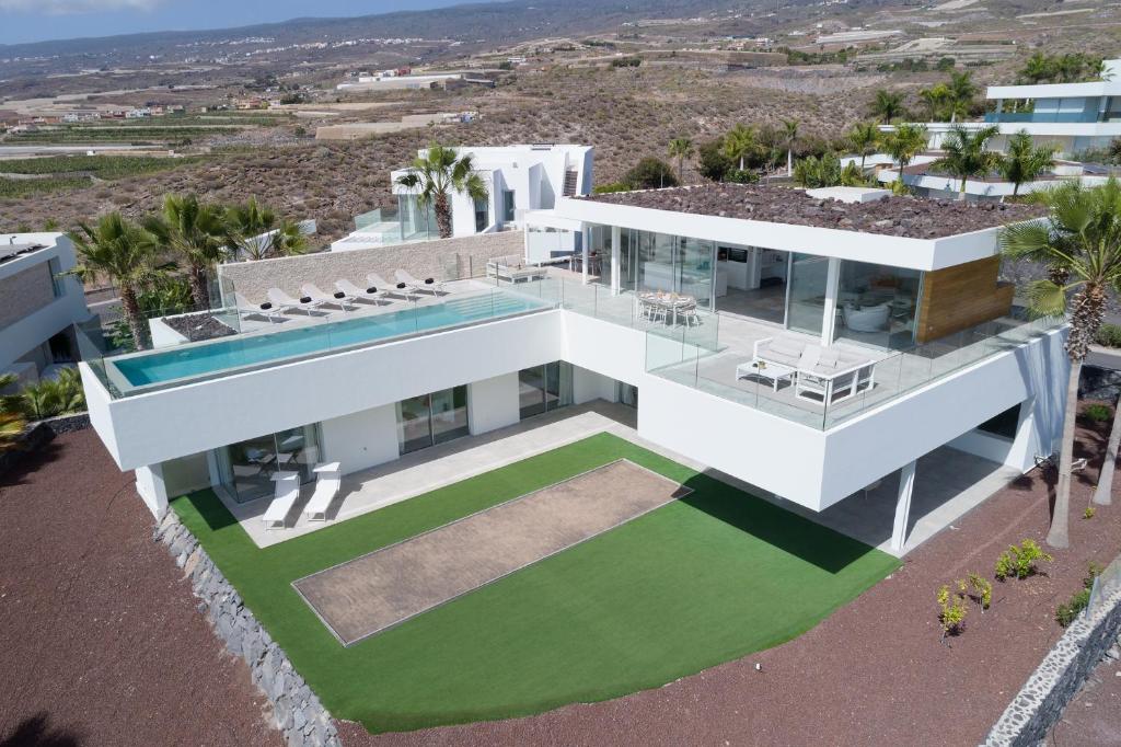 an aerial view of a white house with a lawn at KARAT Villa Zambrano - INCLUDES GOLF CART and DAILY MAID SERVICE in Guía de Isora