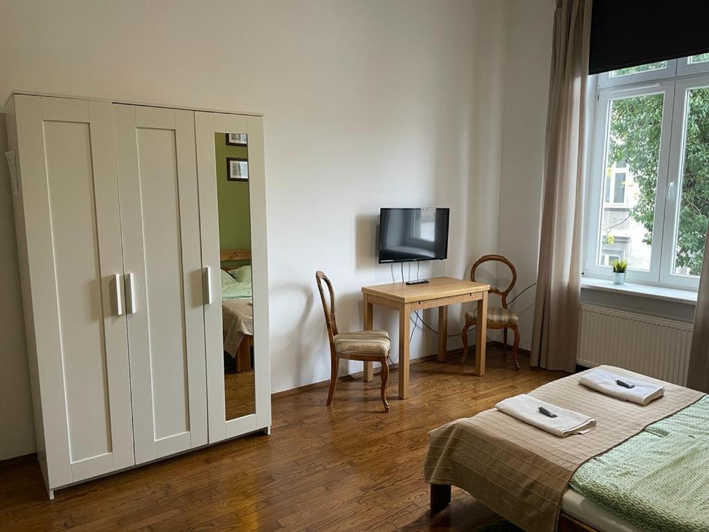 クラクフにあるClassic apartments Pilsudskiego streetのベッドルーム1室(ベッド1台、デスク、テレビ付)