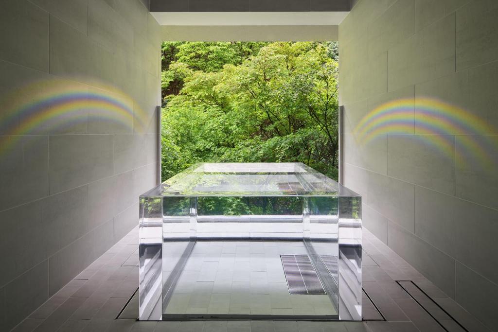Ryokan Sumiya Kihoan في Kameoka: طاولة زجاجية في غرفة مع الانحناء على الحائط