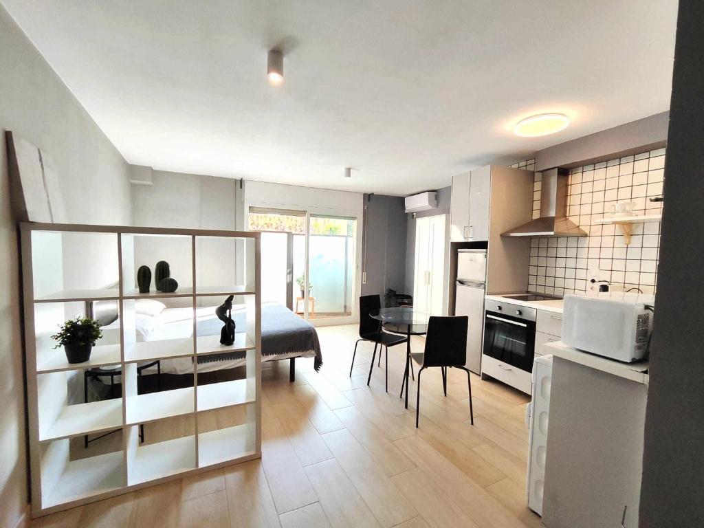 uma sala de estar com uma cama e uma cozinha em Mazi Apartments Suite em Mataró