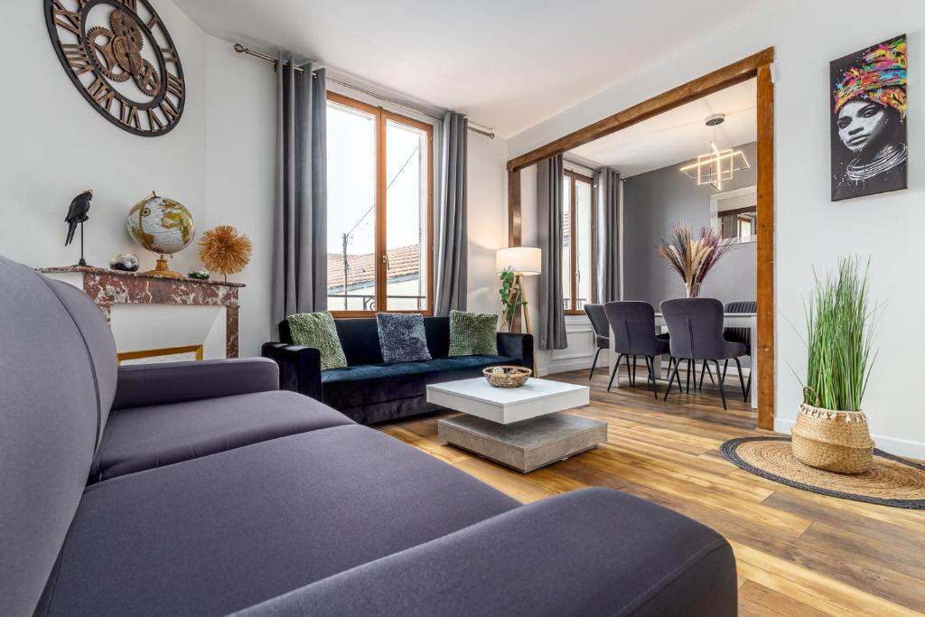 a living room with a couch and a table at Berge - Appartement proche Disneyland Paris in Meaux