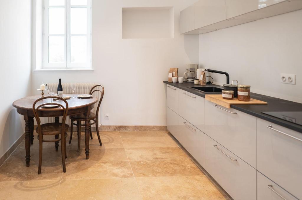 a kitchen with a table and chairs in it at L&#39;appartement du Cellier in Pommard