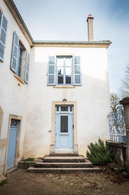 a white house with a blue door at L&#39;appartement du Cellier in Pommard