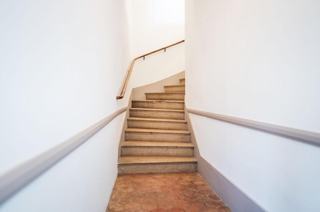 a staircase in a building with white walls and wooden stairs at L&#39;appartement du Cellier in Pommard