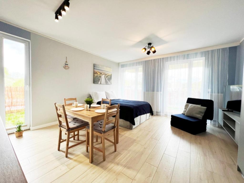 een woonkamer met een tafel en een slaapkamer bij Studio Topaz in Gdańsk