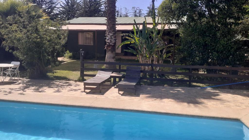 Casa con piscina, mesa y sillas en Cabañas La Querencia de Algarrobo, en Algarrobo