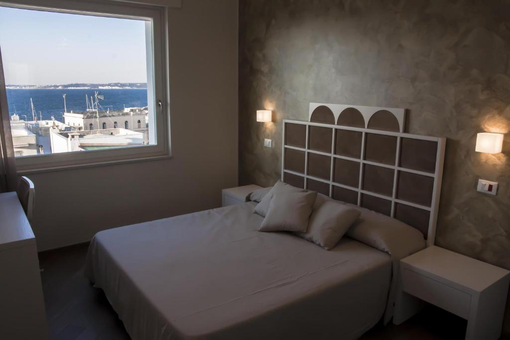 sypialnia z łóżkiem i dużym oknem w obiekcie B&B Ghalà w mieście Gallipoli