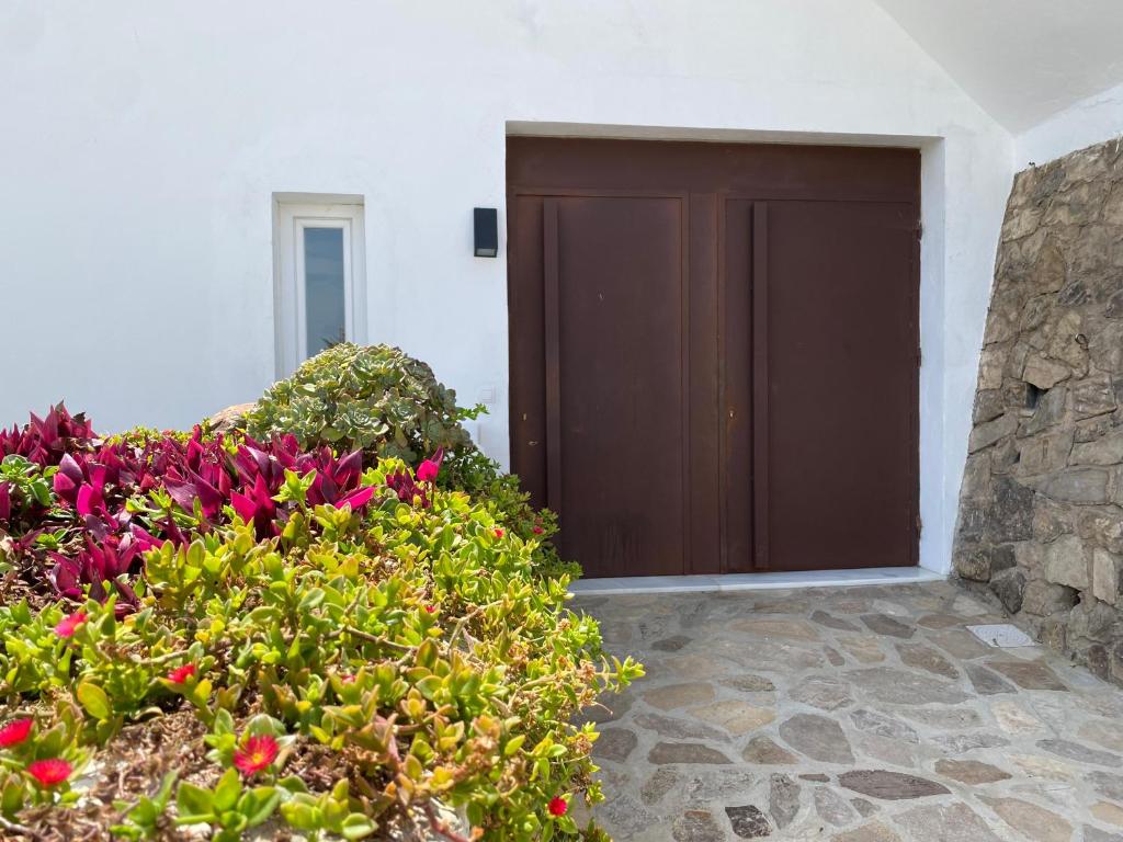 a brown door in a white building with flowers at Armenia apartamento con encanto in Alcalá de los Gazules