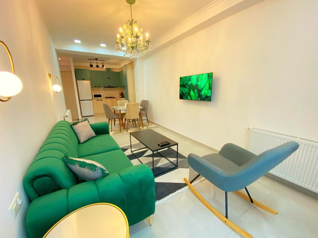 ein Wohnzimmer mit einem grünen Sofa und einem Tisch in der Unterkunft City Heart Luxury Apartment in Kutaissi