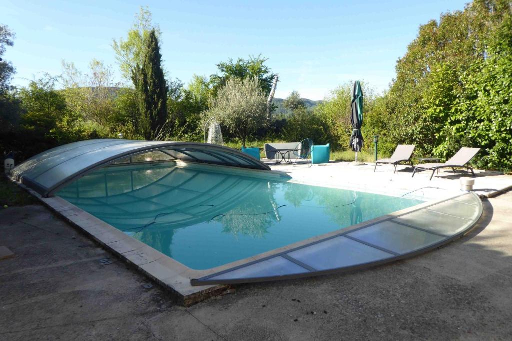 a swimming pool with a boat in a yard at Saint Laurent in Portes-en-Valdaine