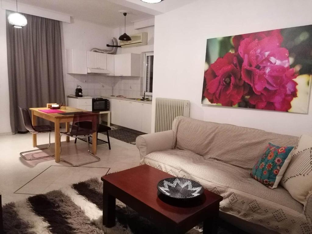 ein Wohnzimmer mit einem Sofa und einem Tisch sowie eine Küche in der Unterkunft Armonia C1 in Tríkala