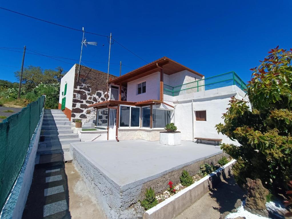 ein kleines weißes Haus mit einer Treppe hinauf in der Unterkunft Vivienda Vacacional Villatajace in Tajace de Abajo