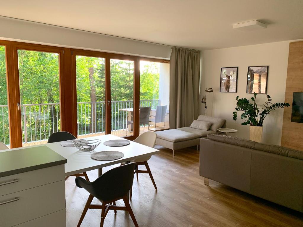 una cucina e un soggiorno con tavolo e sedie di Lipno Port Apartment C101 a Lipno nad Vltavou