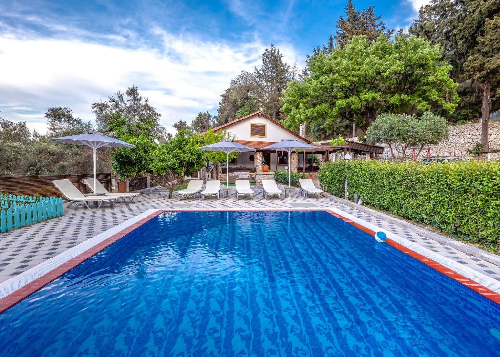 a swimming pool in front of a house at Villa Rafaela in Koskinou